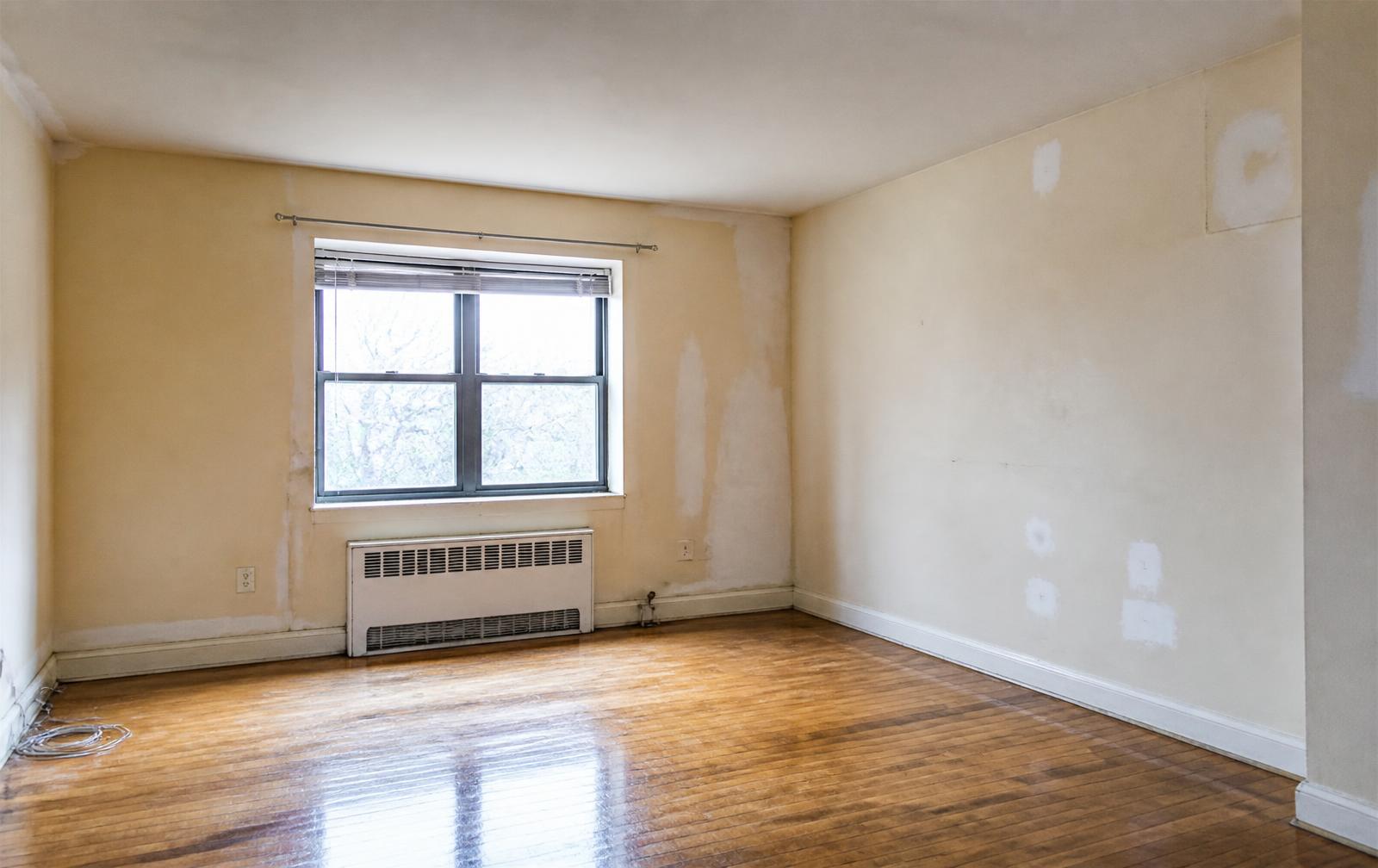 Rental unit before repainting, with scuffed walls and drywall patches